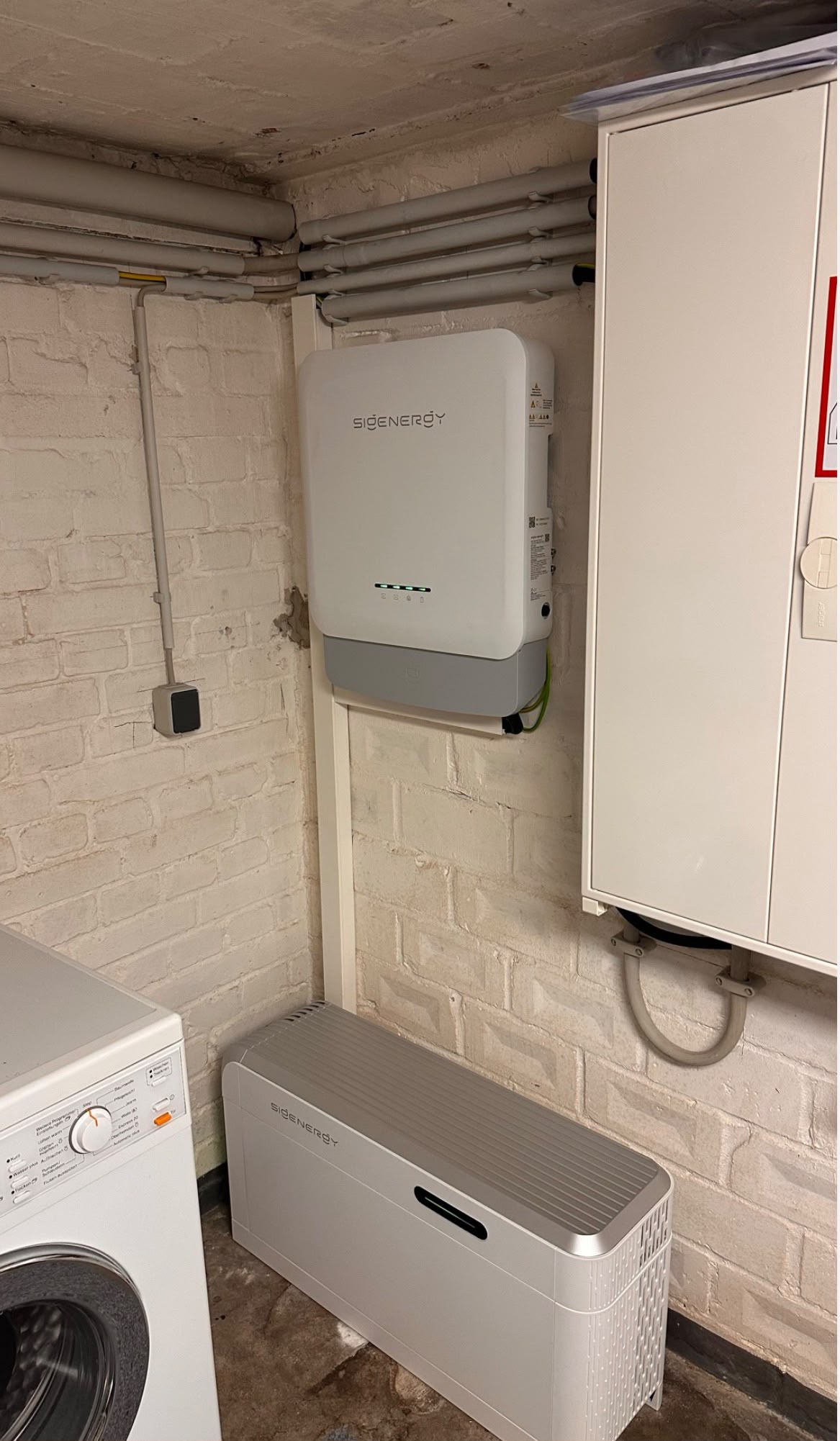 Wechselrichter an der Wand und Batteriespeicher am Boden in einem Technikraum