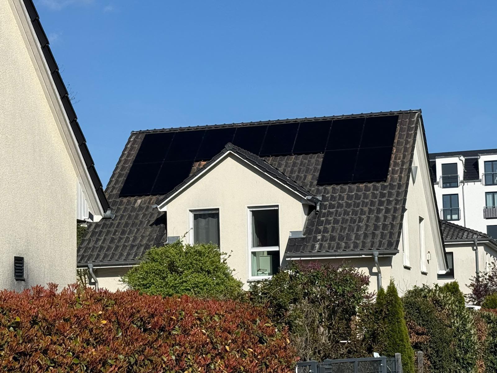 Wohnhaus mit dunklen Photovoltaikmodulen auf dem Satteldach