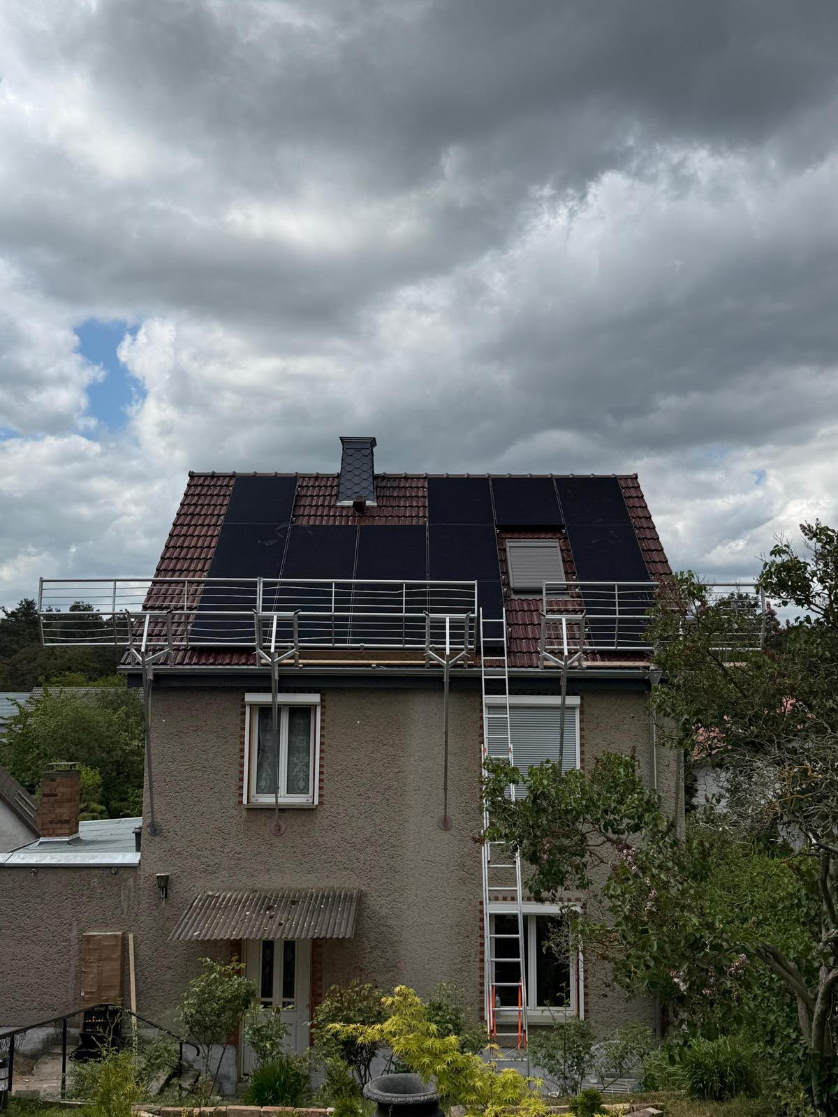 Mehrgeschossiges Wohnhaus mit Photovoltaikanlage auf dem Dach und Balkon