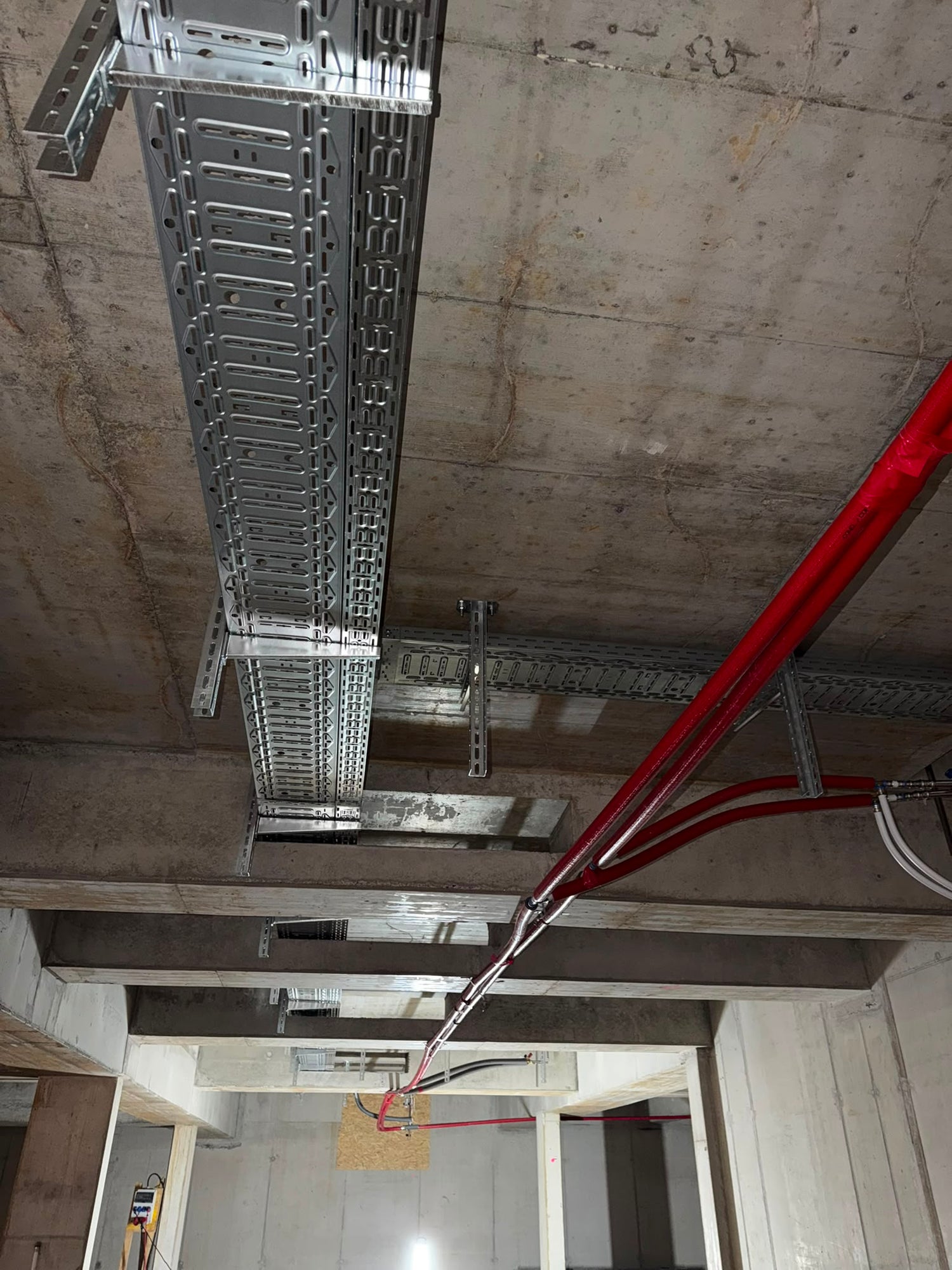 Montierte Kabeltrasse unter einer Betondecke im Rohbau