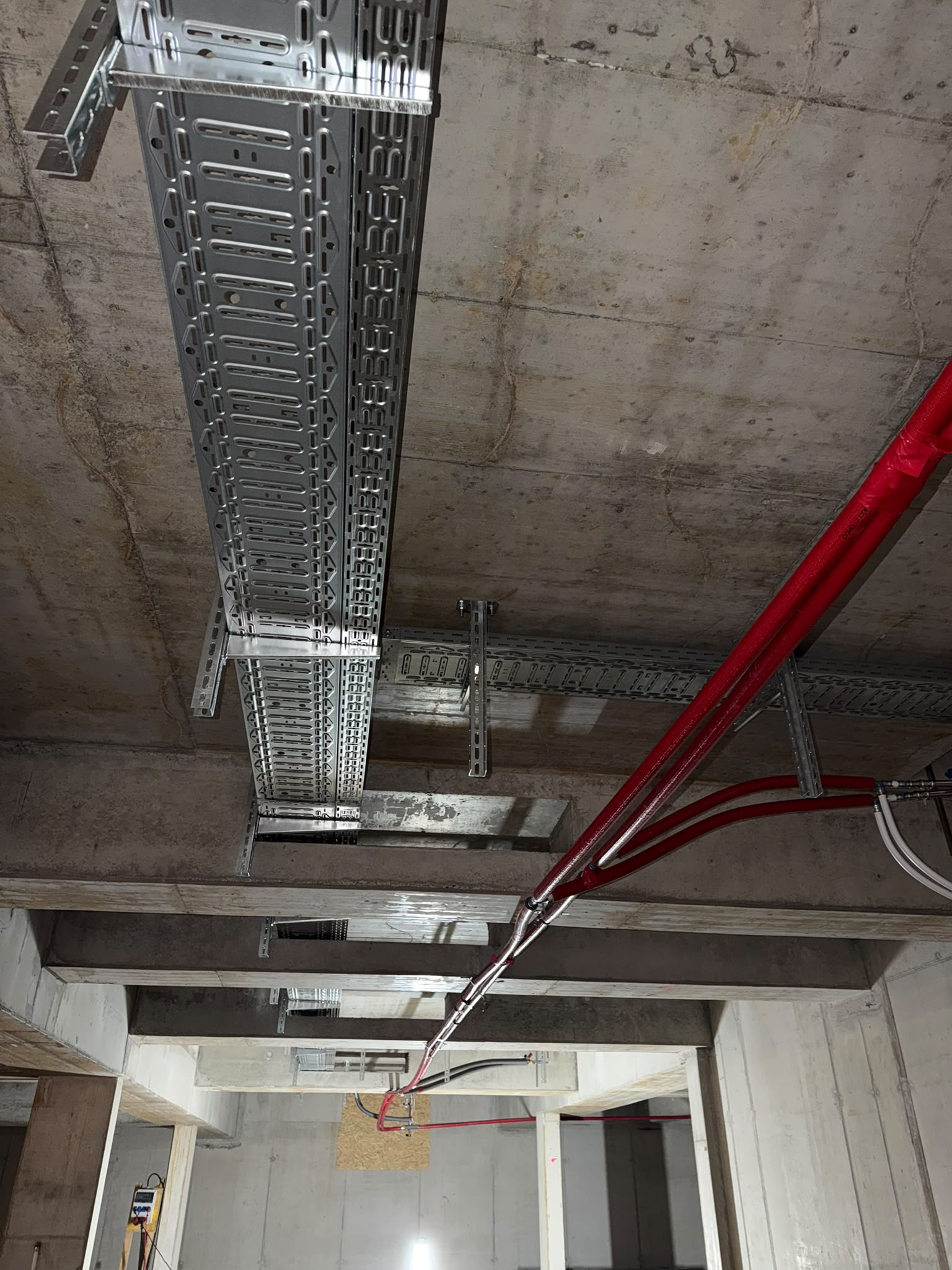Montierte Kabeltrasse unter einer Betondecke im Rohbau