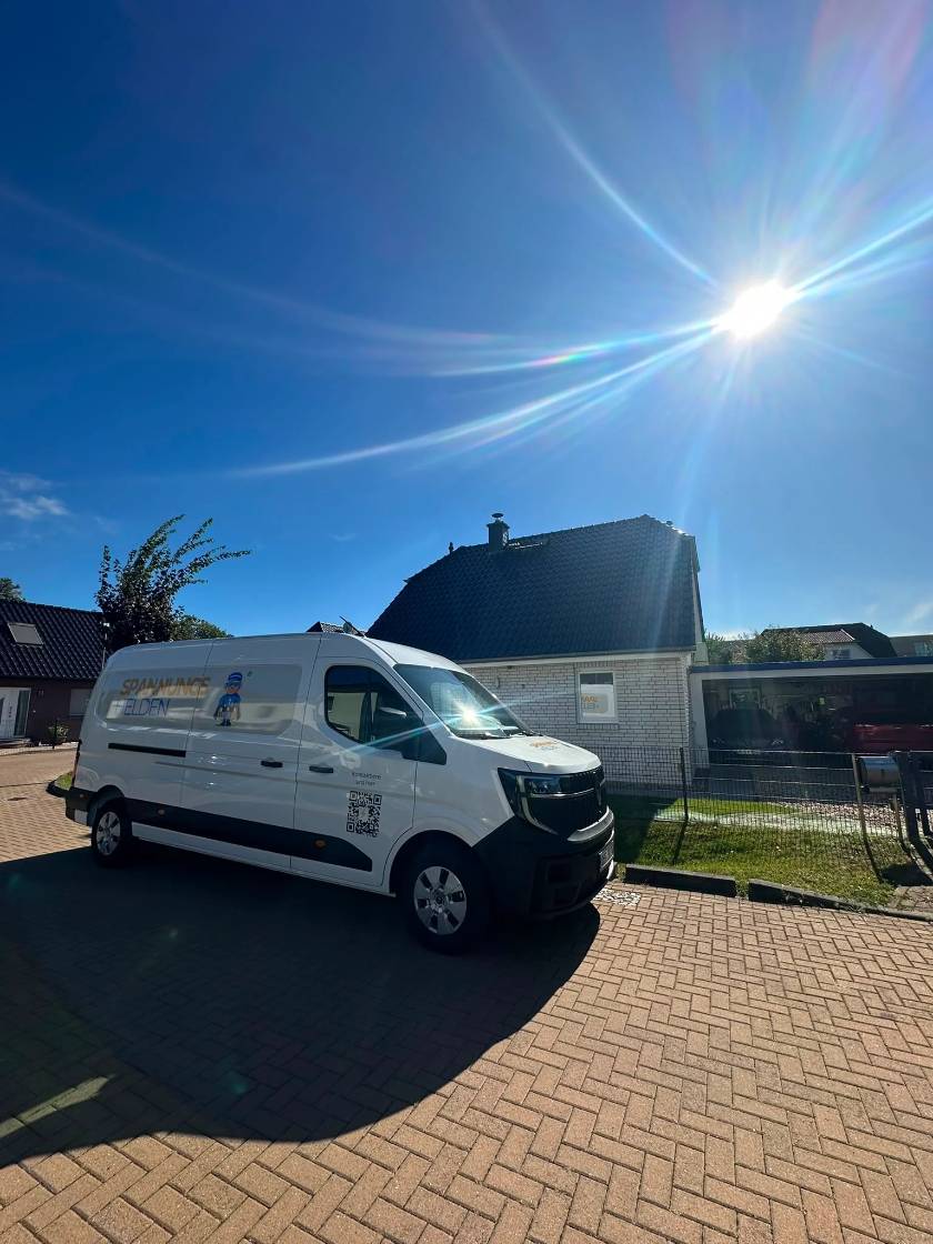 Firmenwagen der Spannungshelden vor einem Einfamilienhaus bei strahlender Sonne